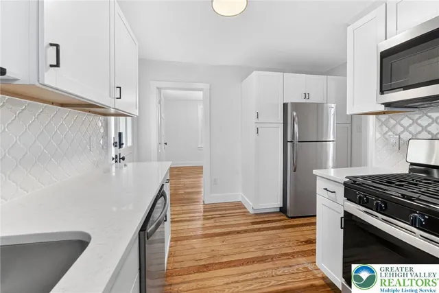 a kitchen with a refrigerator and a stove top oven