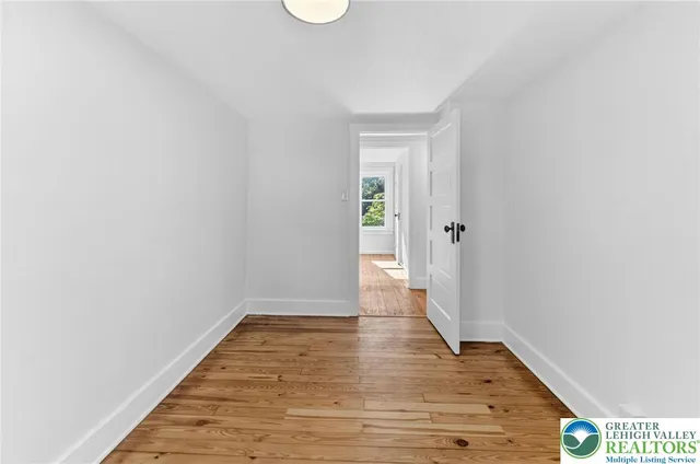 a view of an empty room with wooden floor