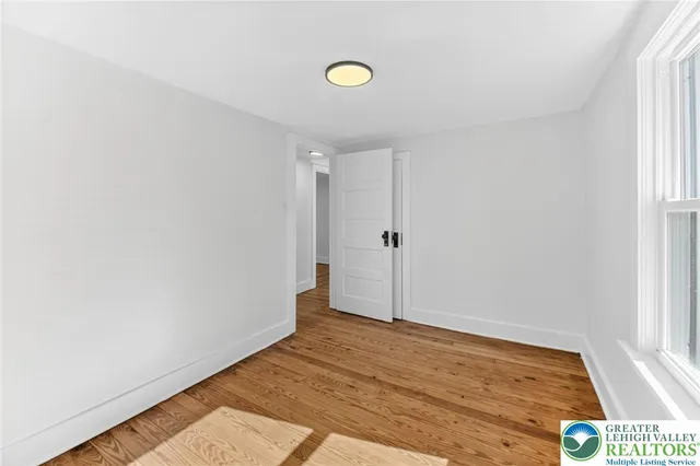 a view of empty room with wooden floor