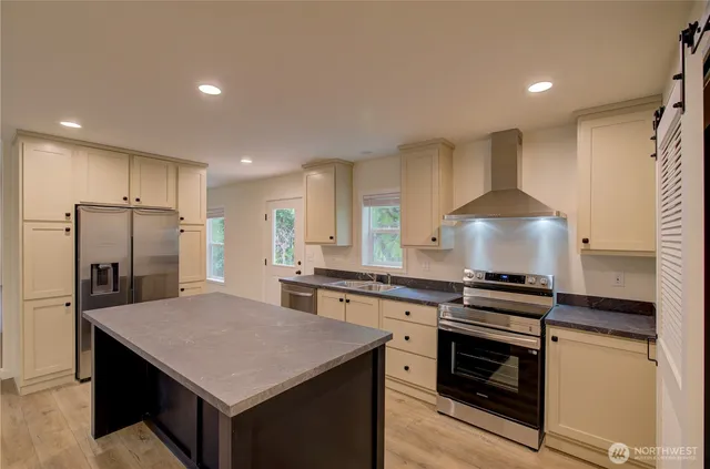 a kitchen with stainless steel appliances granite countertop a sink stove and refrigerator