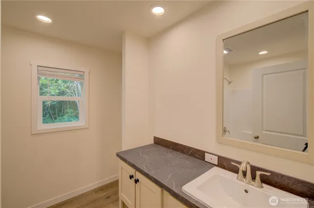 a bathroom with a sink vanity granite and a mirror