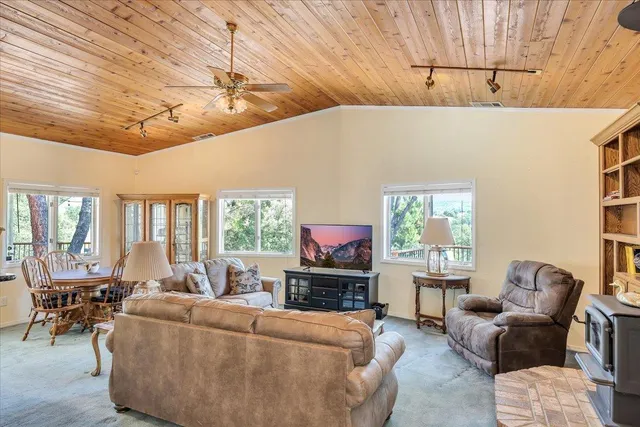 a dining room with furniture large windows and wooden floor
