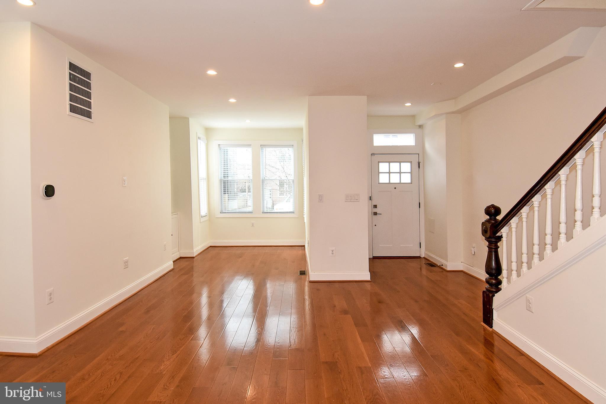 1117 Montello Avenue Northeast Washington, DC 20002 - Photo 4 of 64 a view of an empty room with wooden floor and stairs