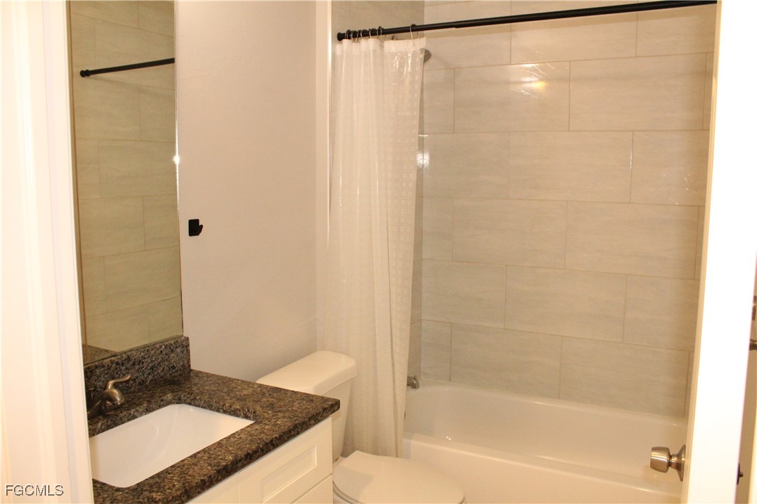 1110 Southwest 47th Terrace, Unit 102 Cape Coral, FL 33914 - Photo 11 of 13 a bathroom with a granite countertop sink and a mirror