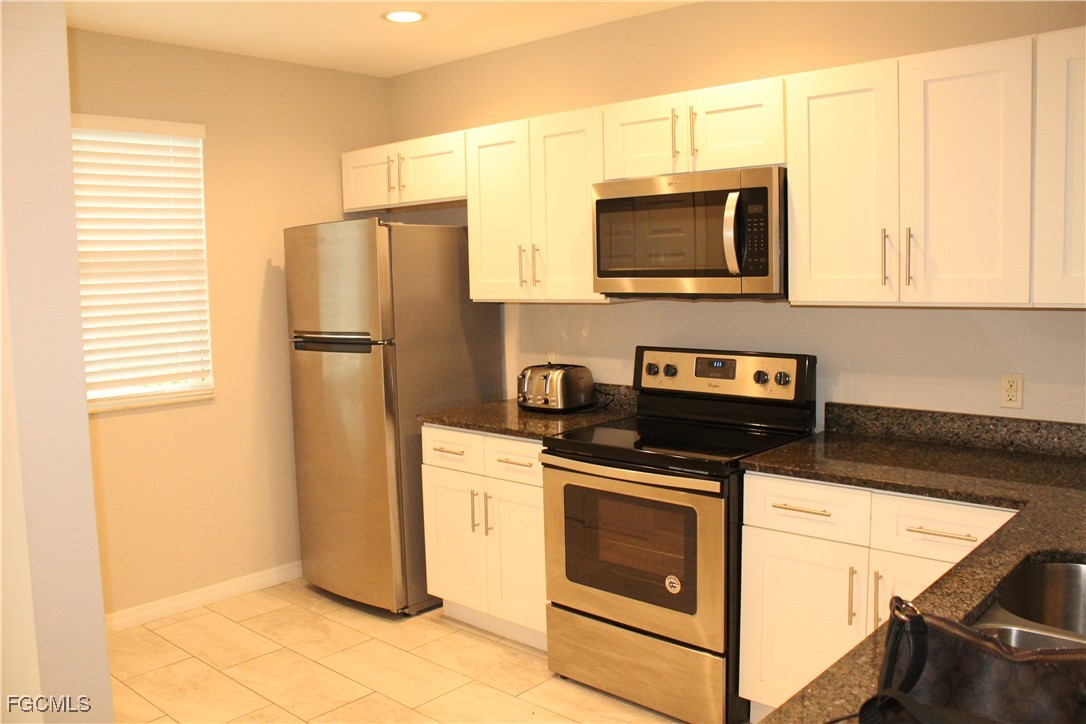 1110 Southwest 47th Terrace, Unit 102 Cape Coral, FL 33914 - Photo 3 of 13 a kitchen with a refrigerator stove and microwave