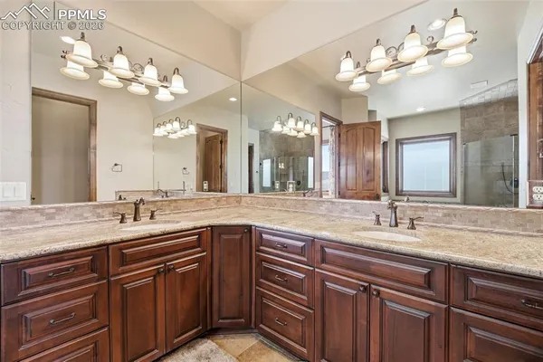 a bathroom with a granite countertop toilet sink and mirror