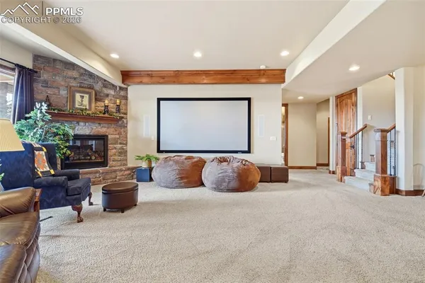 a living room with furniture a flat screen tv and floor to ceiling window