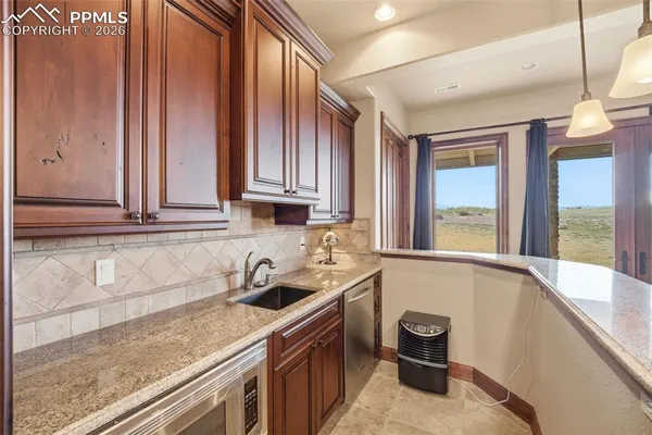 a bathroom with a granite countertop sink a mirror and a shower