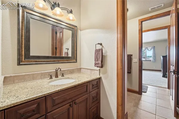 a spacious bathroom with a granite countertop sink a toilet and a mirror