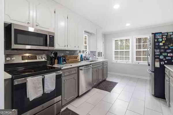 a kitchen with stainless steel appliances a stove a sink and a microwave