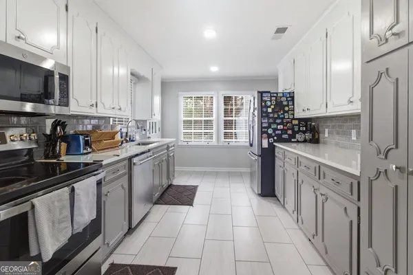 a kitchen with stainless steel appliances a sink stove and cabinets