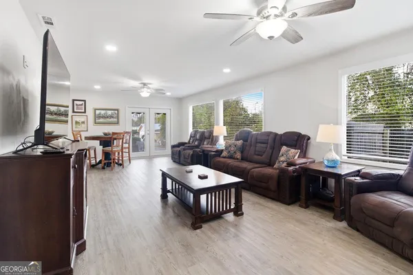 a living room with furniture a ceiling fan and a window