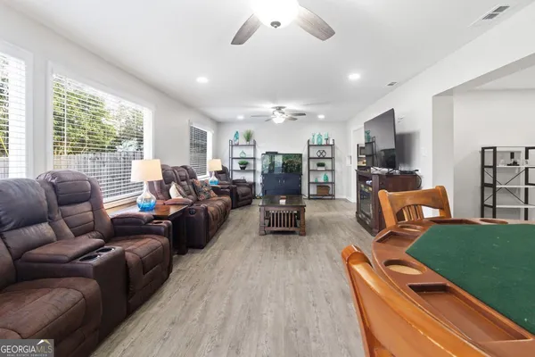 a living room with furniture kitchen view and a large window