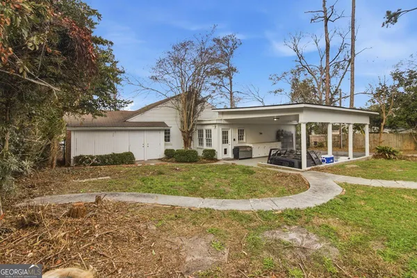 a view of a yard in front of a house with large tree