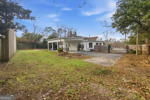 a view of a house with a big yard and large trees