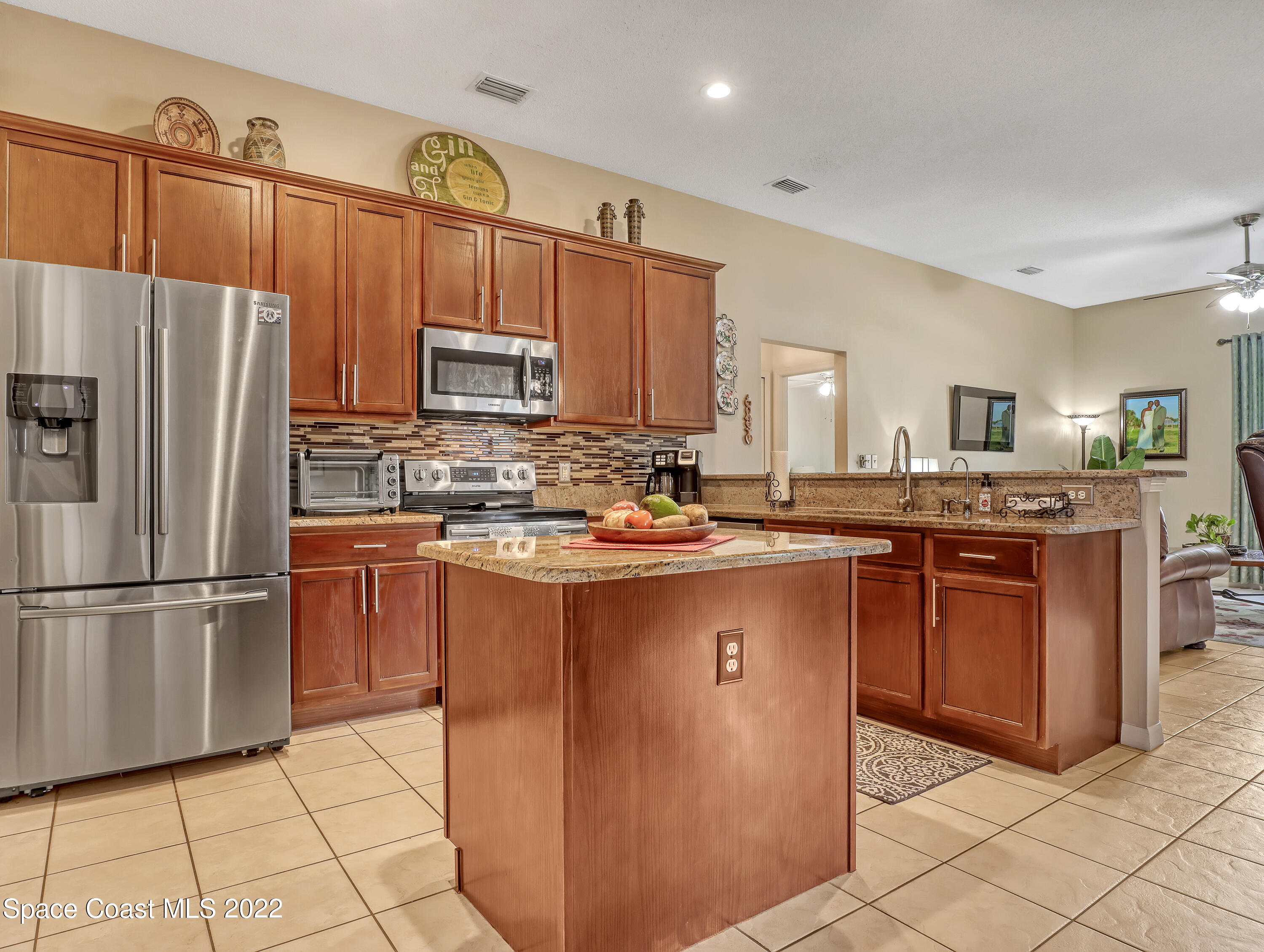 755 Raleigh Road Southeast Palm Bay, FL 32909 - Photo 14 of 36 a kitchen with stainless steel appliances granite countertop a refrigerator a stove a sink and dishwasher