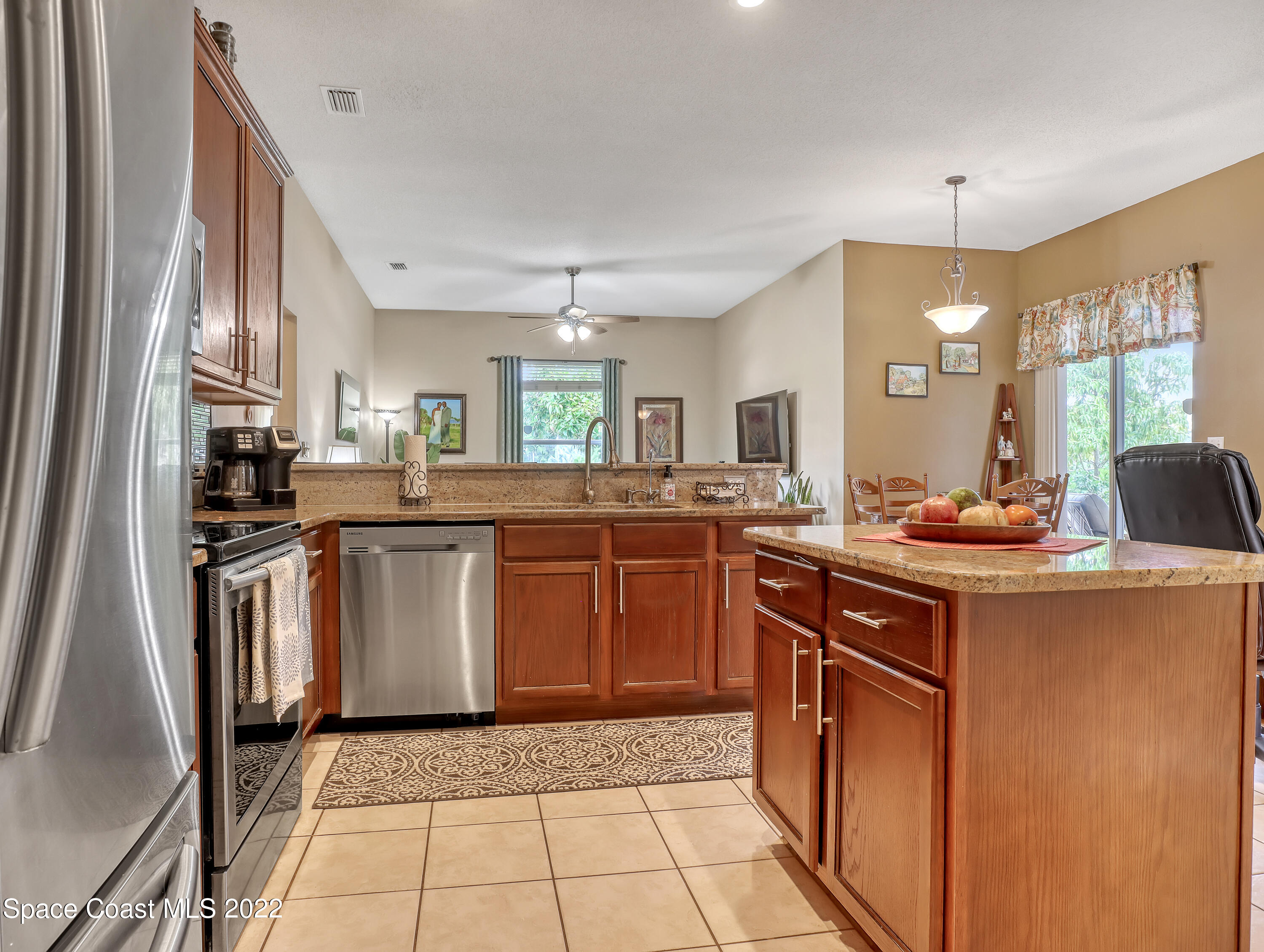 755 Raleigh Road Southeast Palm Bay, FL 32909 - Photo 15 of 36 a kitchen with stainless steel appliances granite countertop a sink and a refrigerator