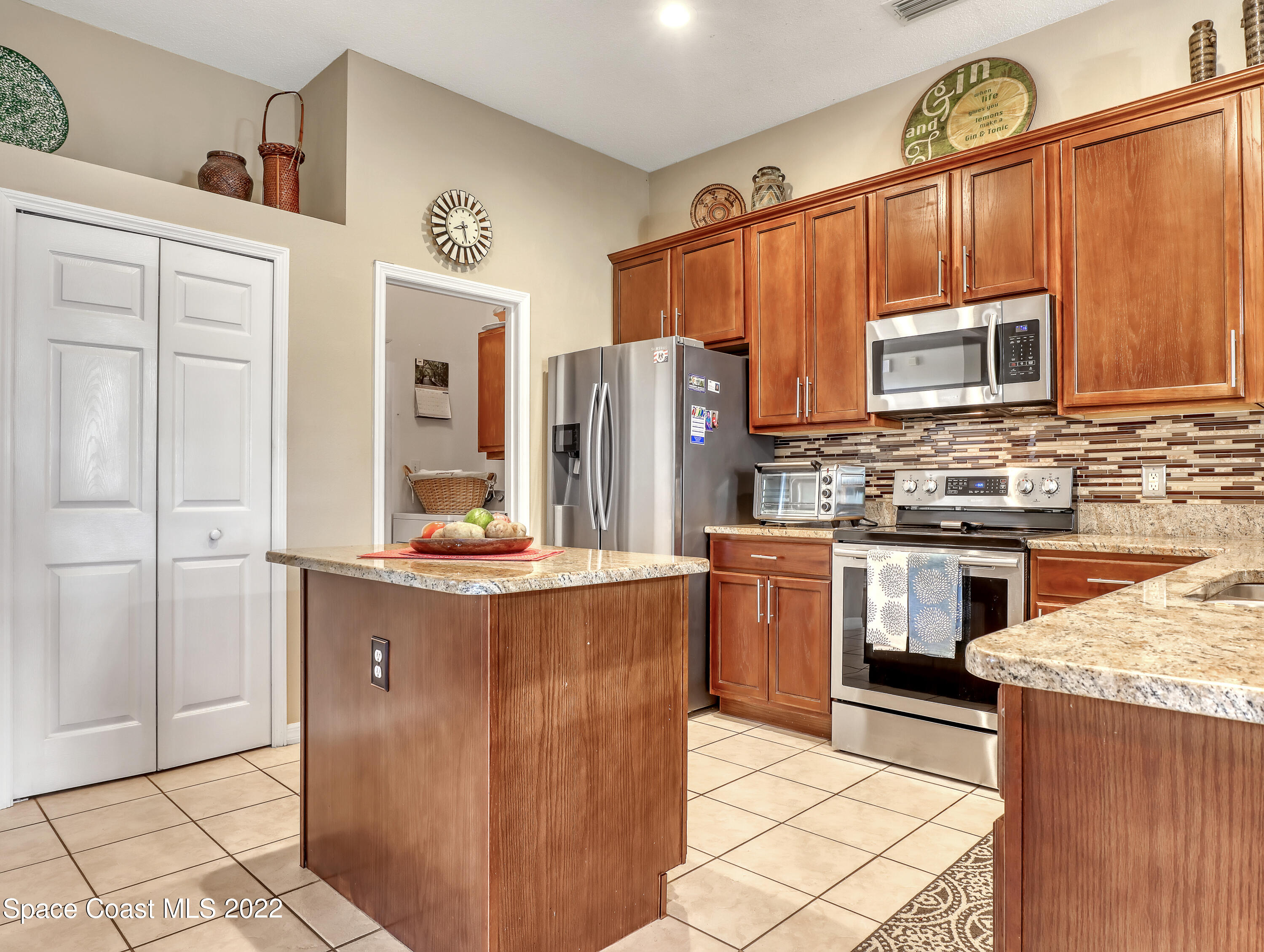 755 Raleigh Road Southeast Palm Bay, FL 32909 - Photo 16 of 36 a kitchen with stainless steel appliances granite countertop a stove a sink and a refrigerator