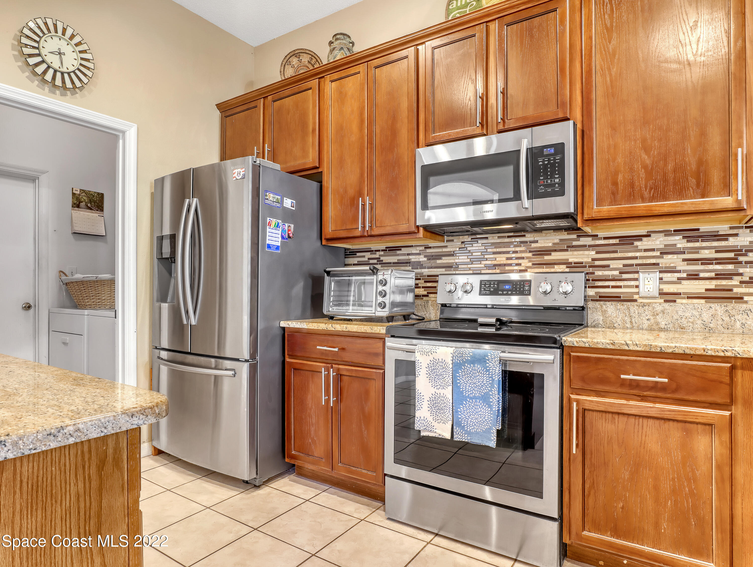 755 Raleigh Road Southeast Palm Bay, FL 32909 - Photo 17 of 36 a kitchen with granite countertop a refrigerator stove and microwave