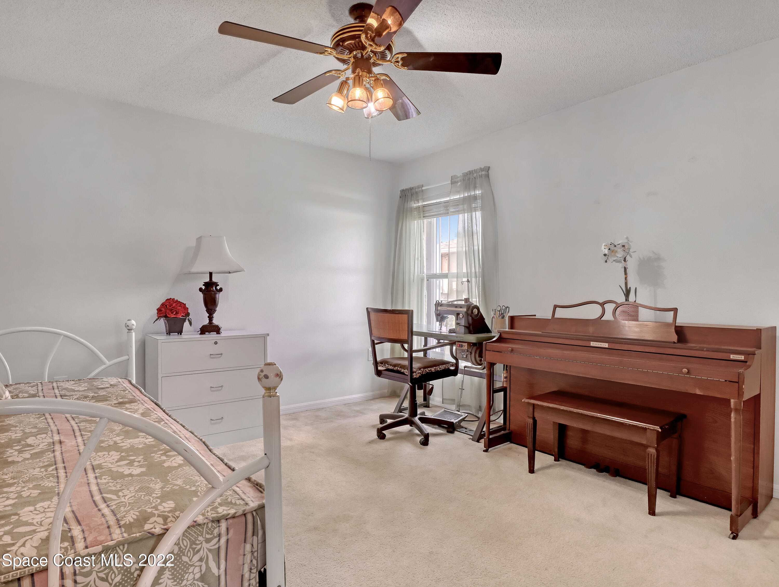 755 Raleigh Road Southeast Palm Bay, FL 32909 - Photo 25 of 36 a room with a chandelier a air conditioner and a couch