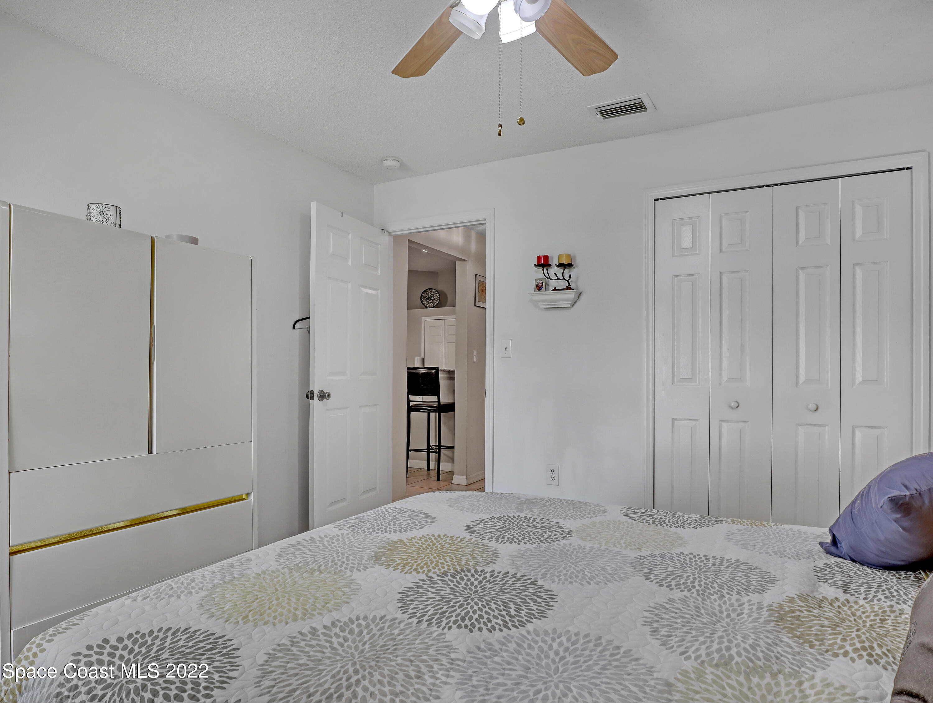 755 Raleigh Road Southeast Palm Bay, FL 32909 - Photo 28 of 36 a bedroom with a bed and a chandelier fan