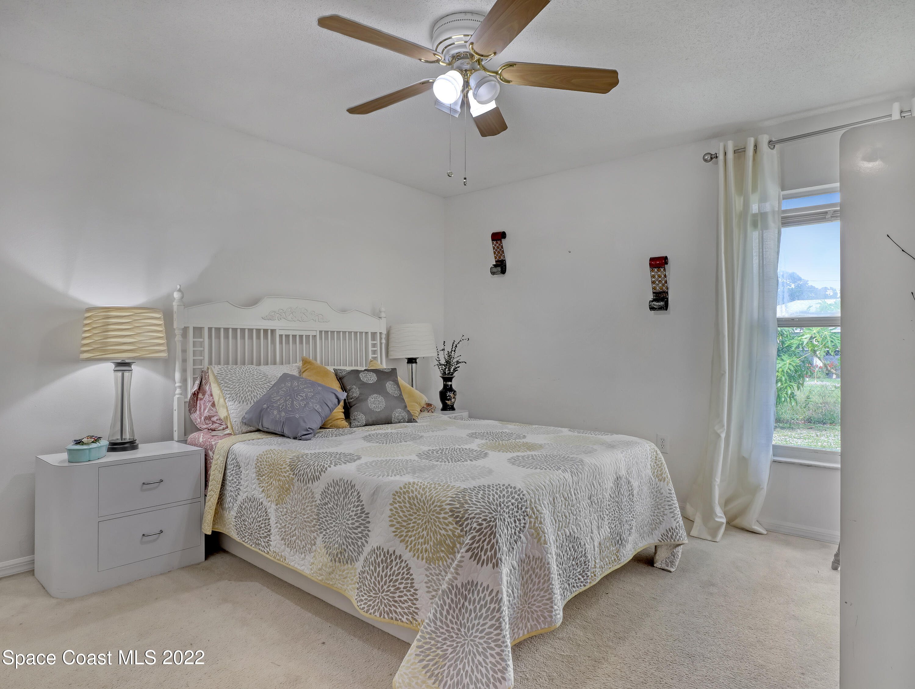 755 Raleigh Road Southeast Palm Bay, FL 32909 - Photo 29 of 36 a bedroom with a bed and a chandelier