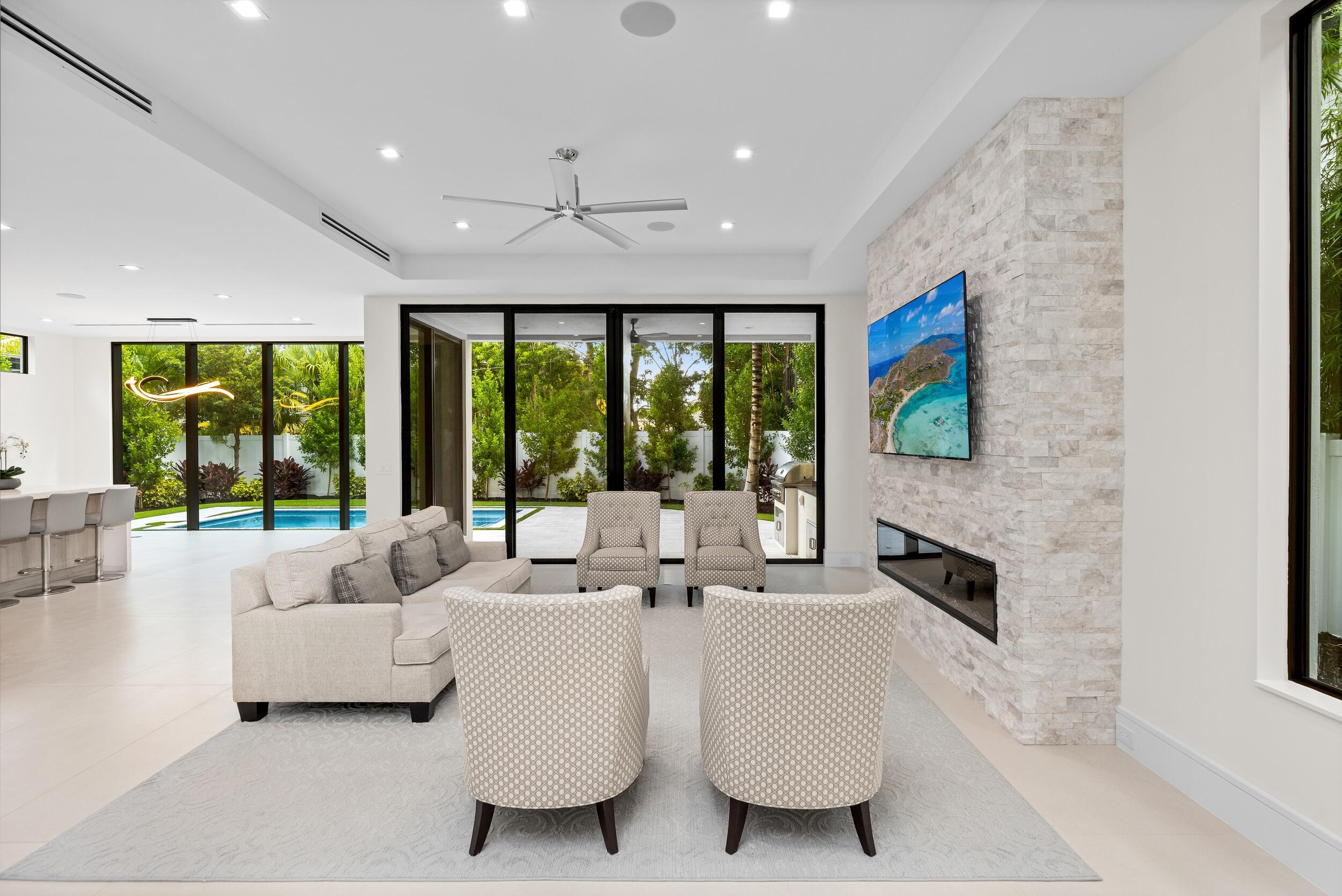 753 Park Drive West Boca Raton, FL 33432 - Photo 22 of 50 a living room with furniture large windows and a fireplace