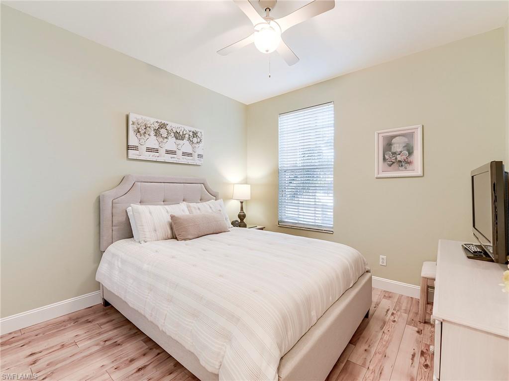 9040 Spring Run Boulevard, Unit 404 Estero, FL 34135 - Photo 18 of 34 a bedroom with a bed and a flat screen tv