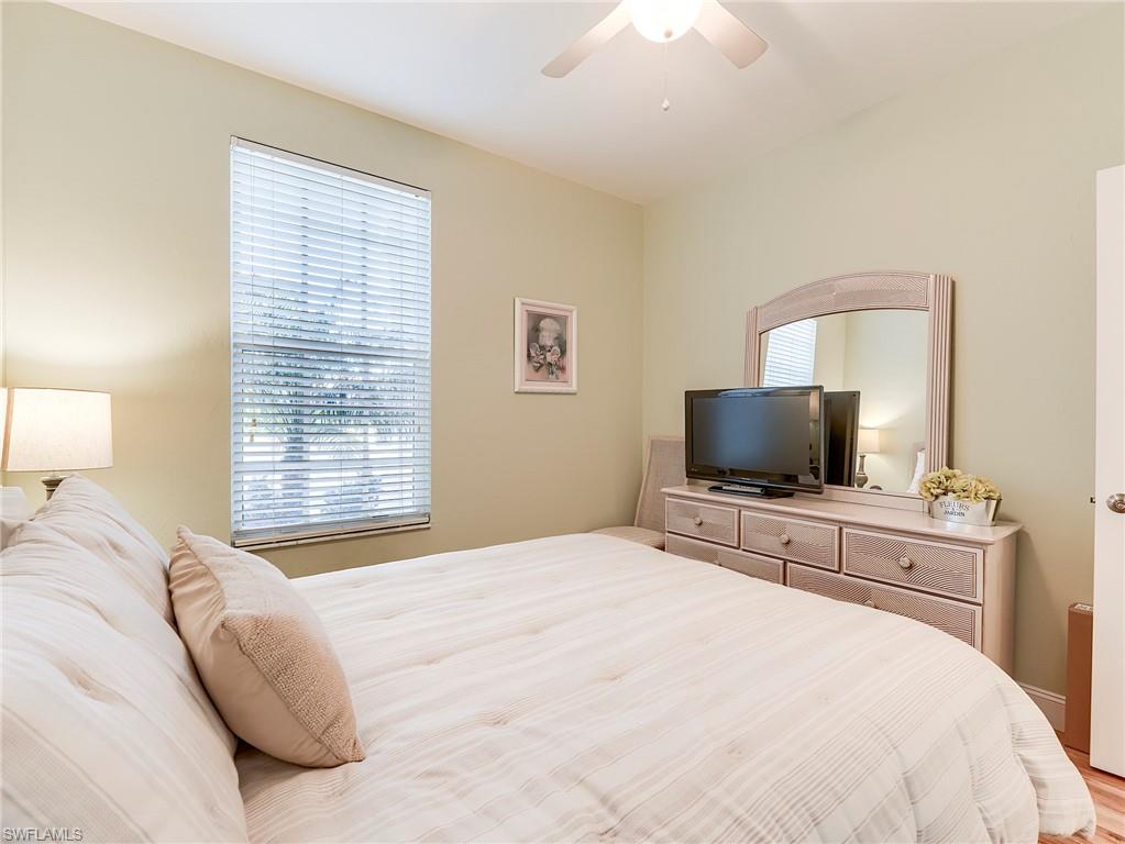 9040 Spring Run Boulevard, Unit 404 Estero, FL 34135 - Photo 19 of 34 a bedroom with a bed and a flat screen tv