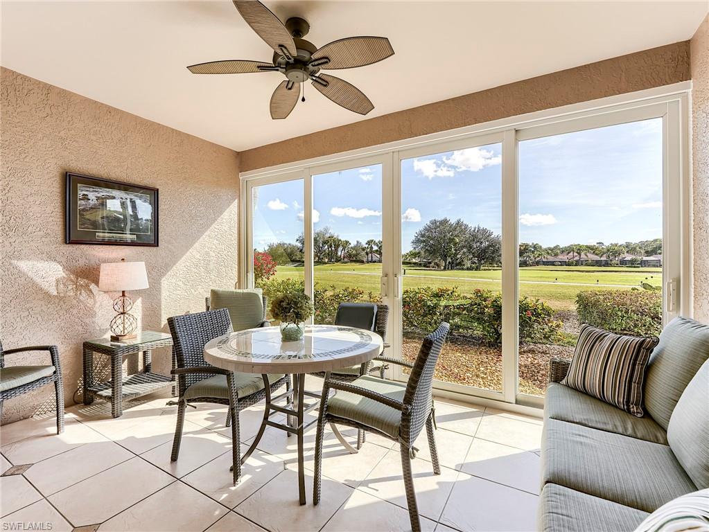 9040 Spring Run Boulevard, Unit 404 Estero, FL 34135 - Photo 2 of 34 a living room with furniture and floor to ceiling windows
