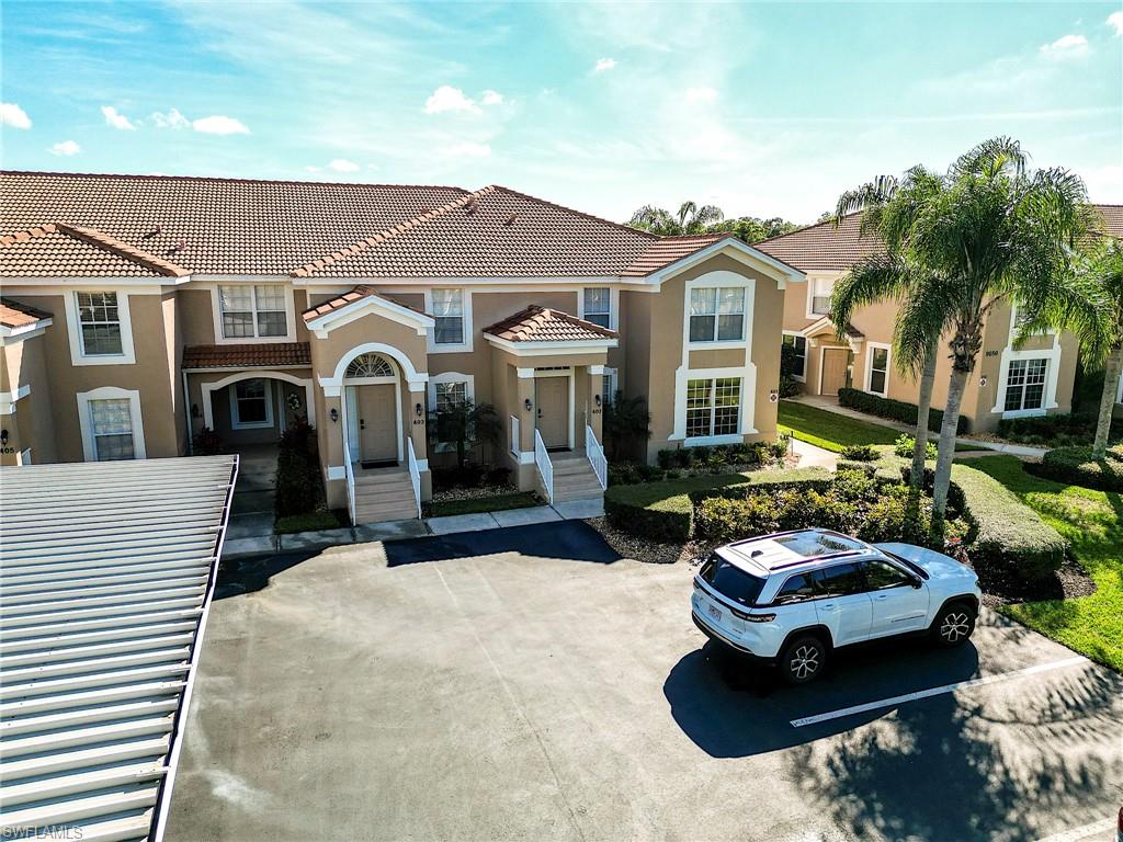 9040 Spring Run Boulevard, Unit 404 Estero, FL 34135 - Photo 22 of 34 a front view of a house with a garden and patio
