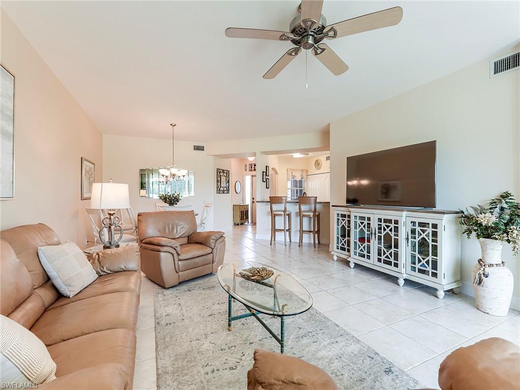 9040 Spring Run Boulevard, Unit 404 Estero, FL 34135 - Photo 5 of 34 a living room with furniture and a flat screen tv