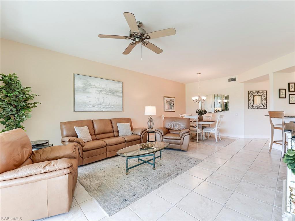 9040 Spring Run Boulevard, Unit 404 Estero, FL 34135 - Photo 7 of 34 a living room with furniture and a chandelier