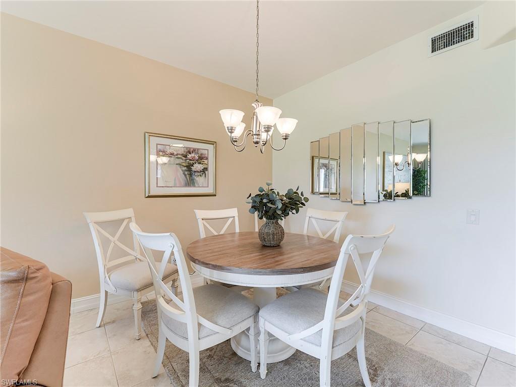 9040 Spring Run Boulevard, Unit 404 Estero, FL 34135 - Photo 9 of 34 a dining room with furniture and a chandelier
