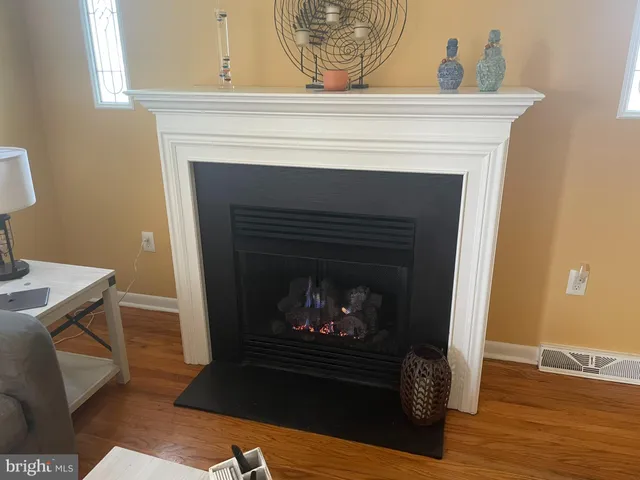 a living room with a fireplace and a wooden floor