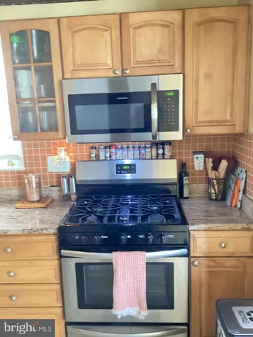 a kitchen with stainless steel appliances granite countertop a stove and a sink