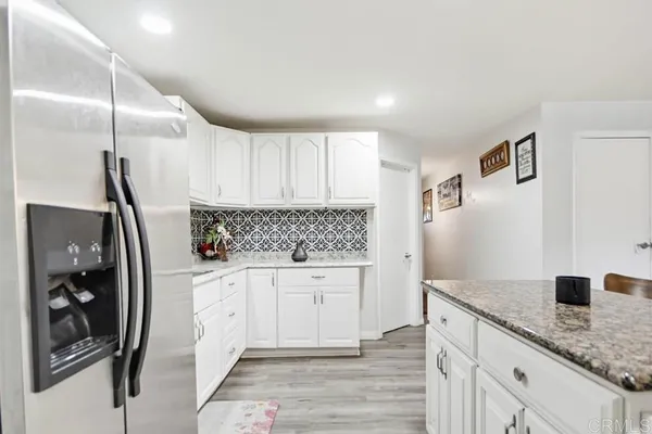 a kitchen with granite countertop a table and chairs in it