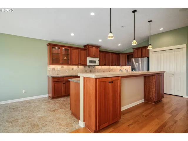 a kitchen with kitchen island a sink stainless steel appliances and cabinets