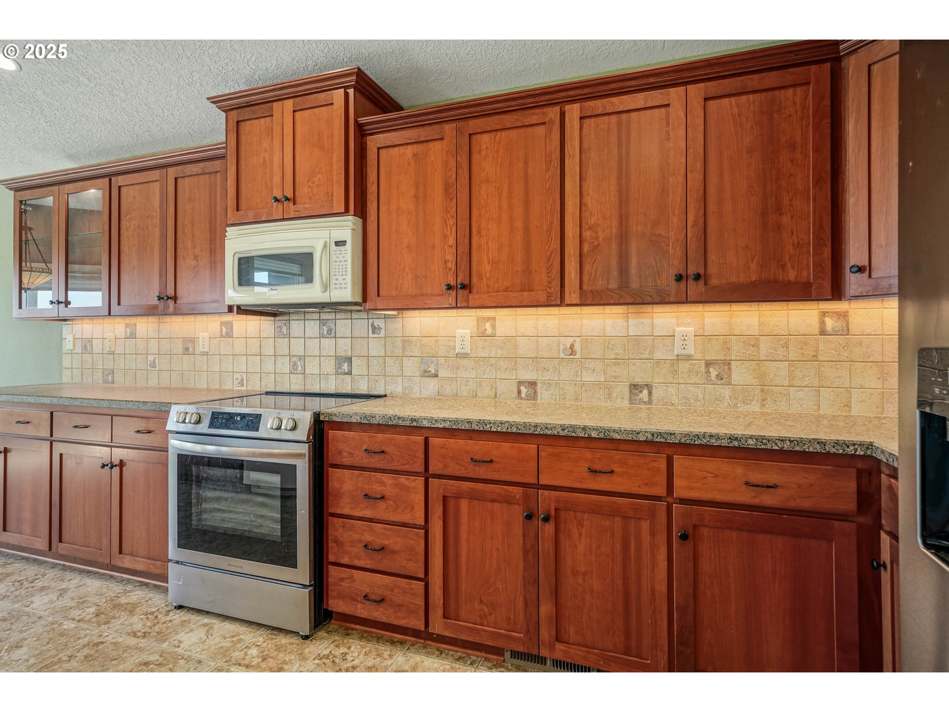 736 Southeast St Andrews Lane Dallas, OR 97338 - Photo 23 of 35 a kitchen with stainless steel appliances granite countertop wooden cabinets a stove top oven
