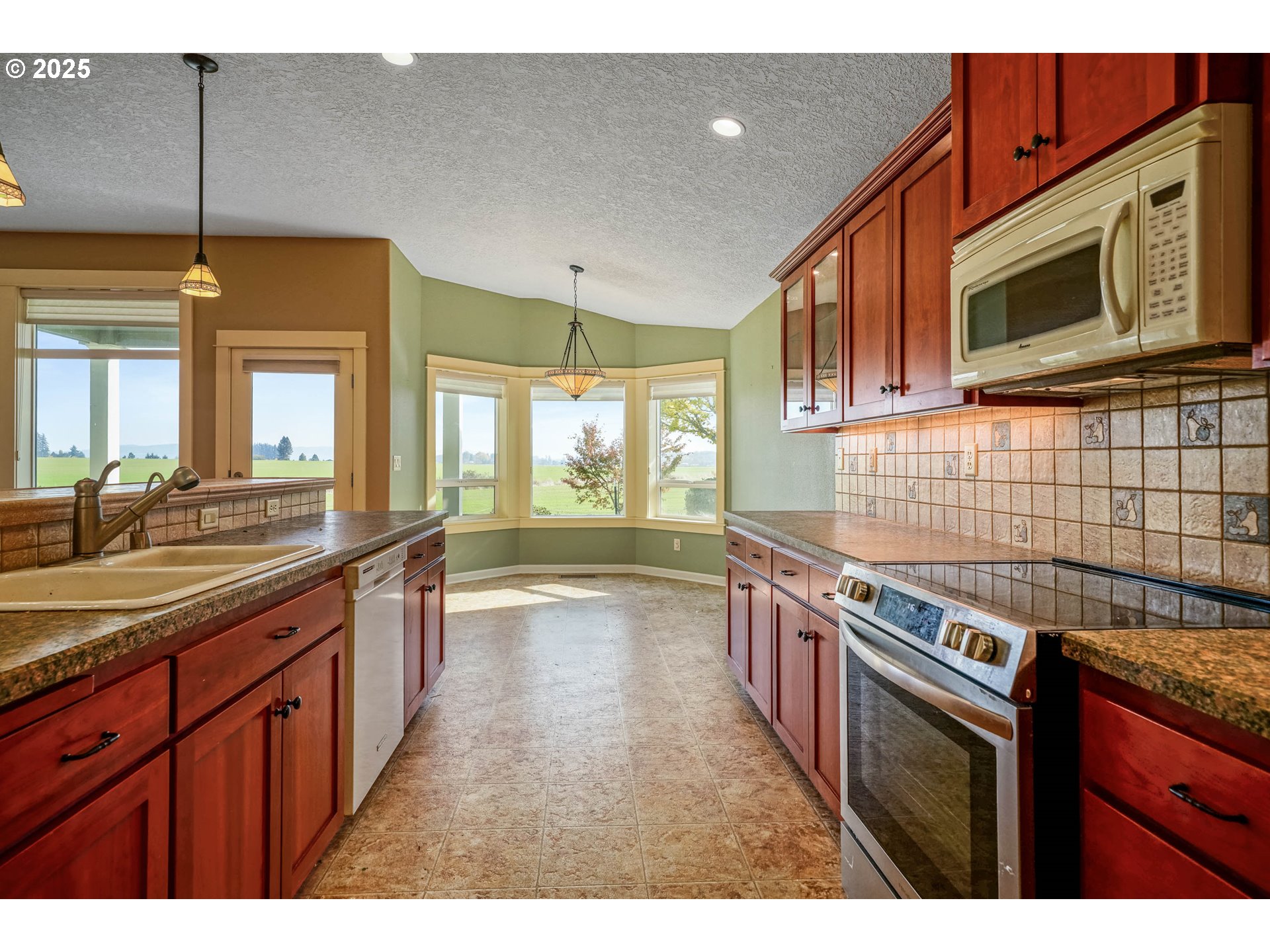 736 Southeast St Andrews Lane Dallas, OR 97338 - Photo 24 of 35 a kitchen with stainless steel appliances granite countertop a sink and a stove