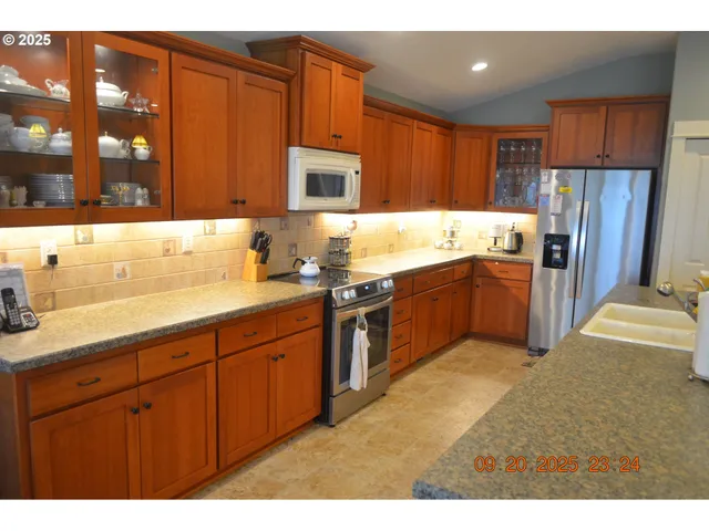 a kitchen with stainless steel appliances granite countertop a sink stove and refrigerator
