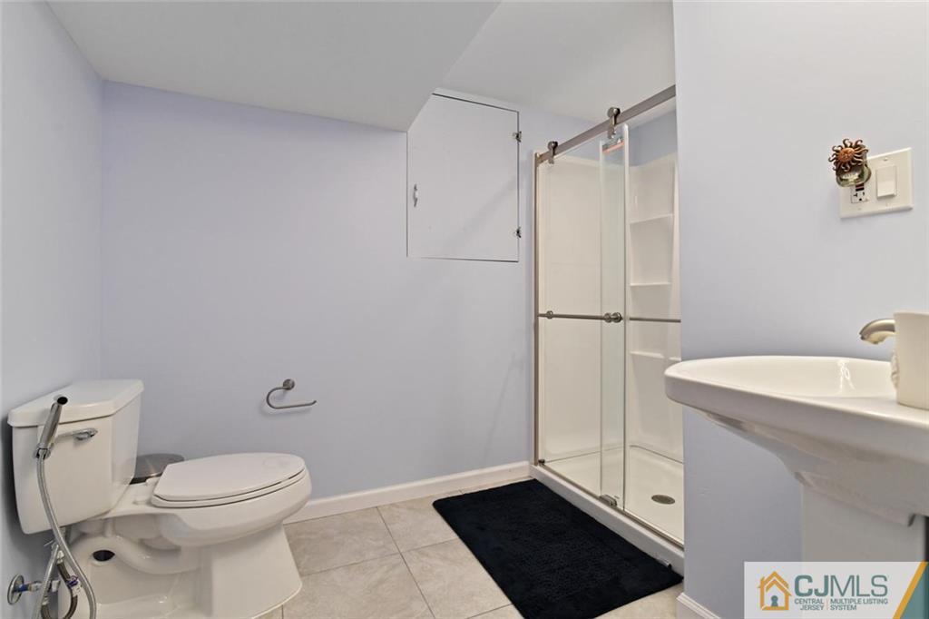 18 Tamarack Road Edison, NJ 08820 - Photo 17 of 25 a bathroom with a sink a toilet a shower and a mirror