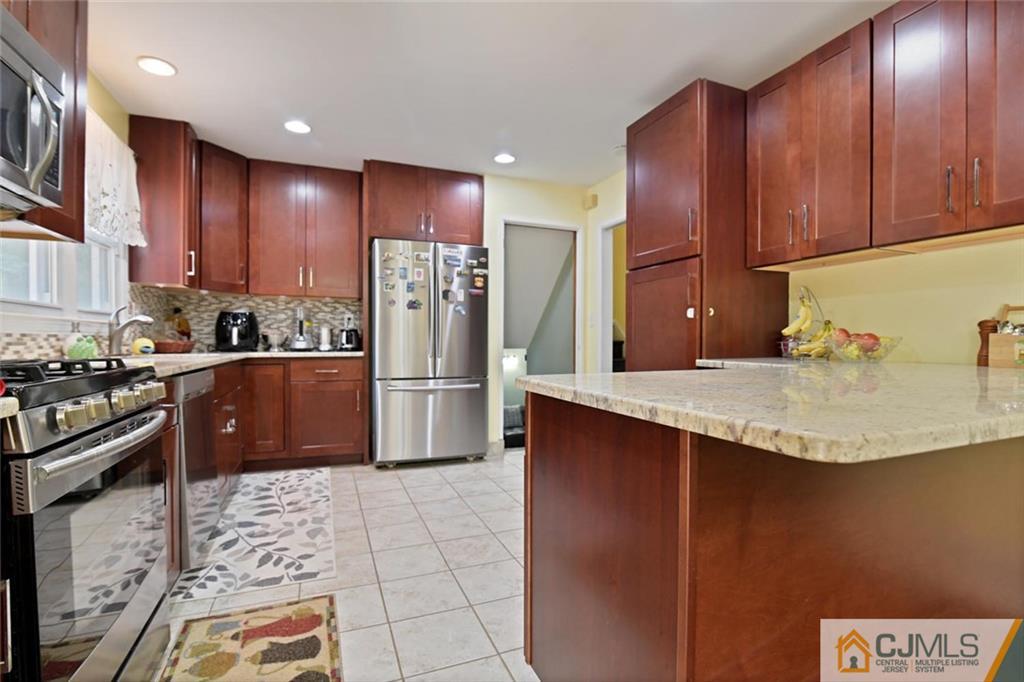 18 Tamarack Road Edison, NJ 08820 - Photo 7 of 25 a kitchen with stainless steel appliances granite countertop a sink counter space and cabinets