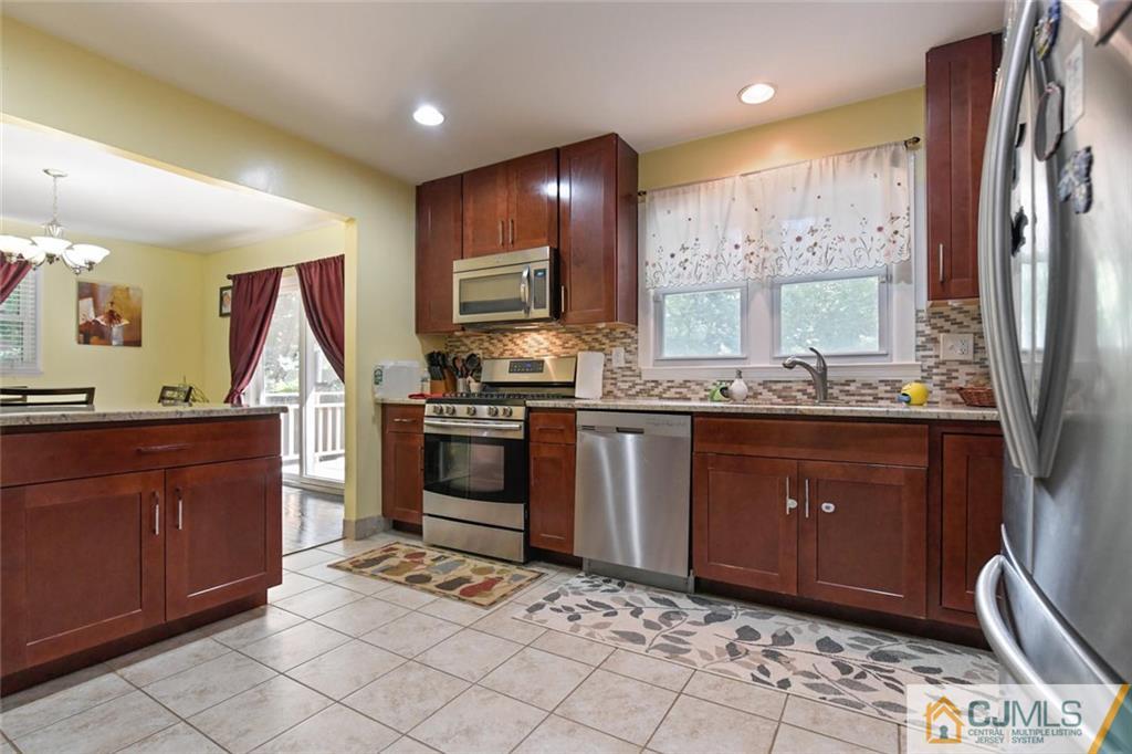 18 Tamarack Road Edison, NJ 08820 - Photo 8 of 25 a kitchen with stainless steel appliances granite countertop a sink stove and refrigerator