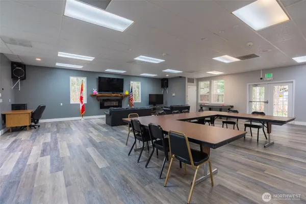 a dining room with stainless steel appliances wooden floor dining table and chairs