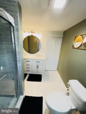 a bathroom with a toilet a sink and mirror