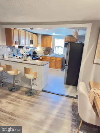 a living room with granite countertop furniture a rug and kitchen view