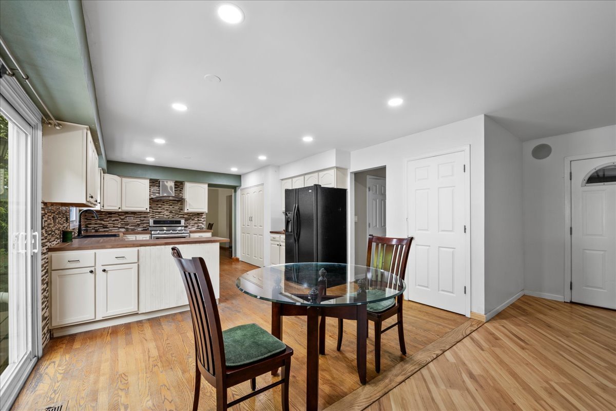 1554 Deer Run Road Gurnee, IL 60031 - Photo 3 of 24 a kitchen with stainless steel appliances granite countertop a dining table chairs refrigerator and sink