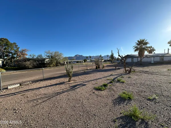 a view of a yard with wooden fence
