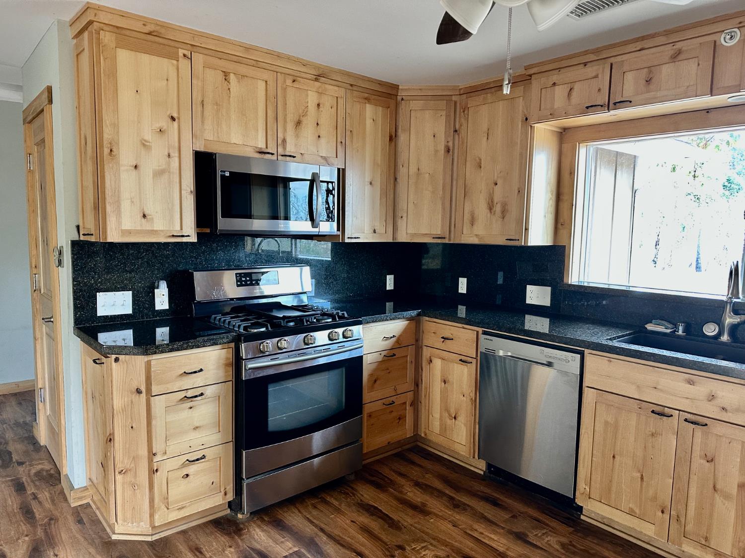38295 Cressman Road Shaver Lake, CA 93664 - Photo 3 of 31 a kitchen with stainless steel appliances granite countertop a stove a sink and a microwave